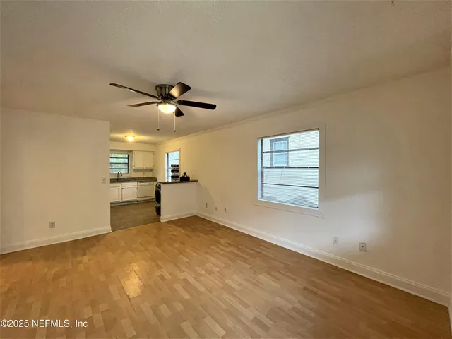 an empty room with cabinet and windows