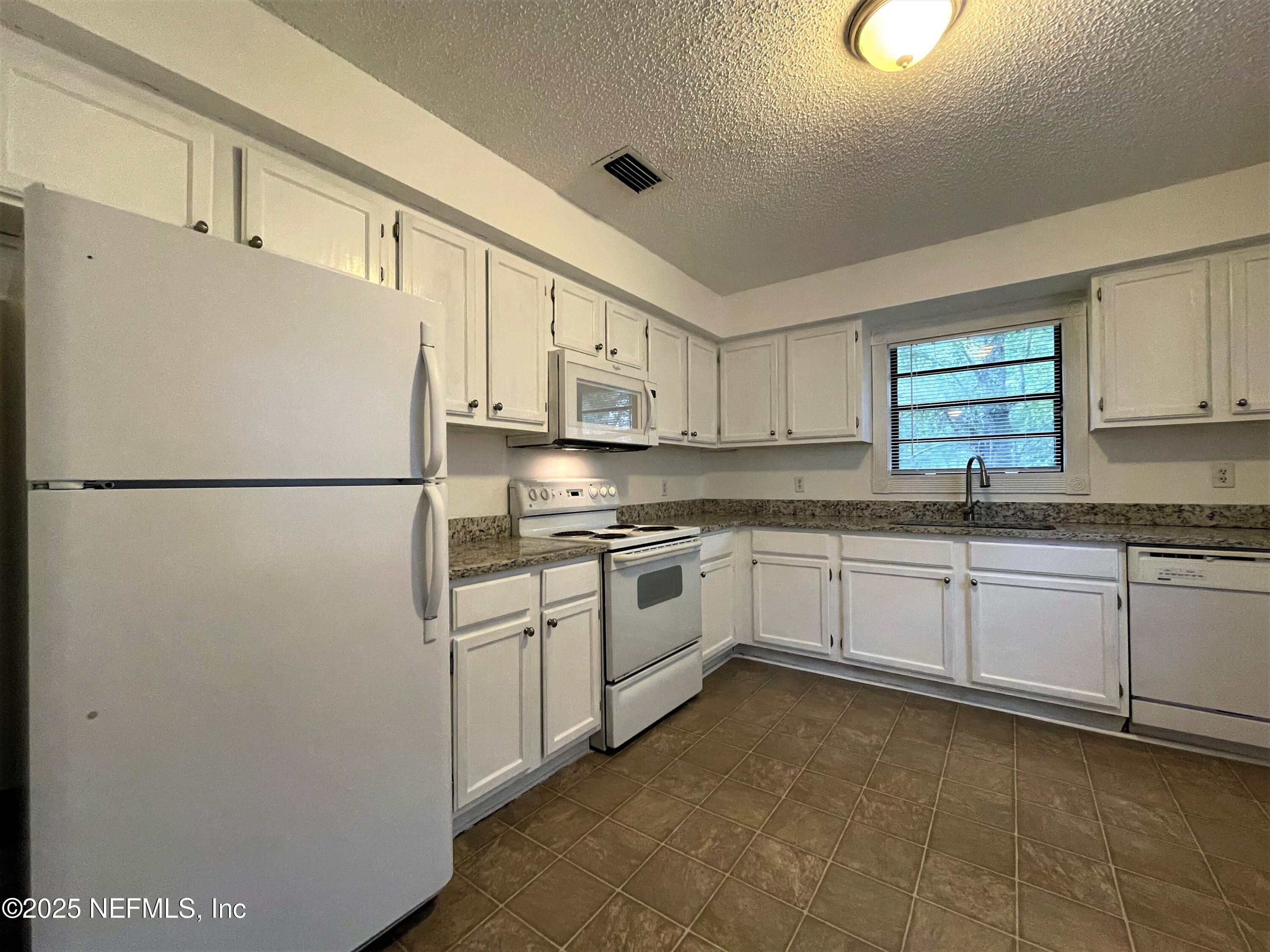 2910 Post Street Jacksonville, FL 32205 - Photo 6 of 12 a kitchen with stainless steel appliances granite countertop a refrigerator sink and cabinets