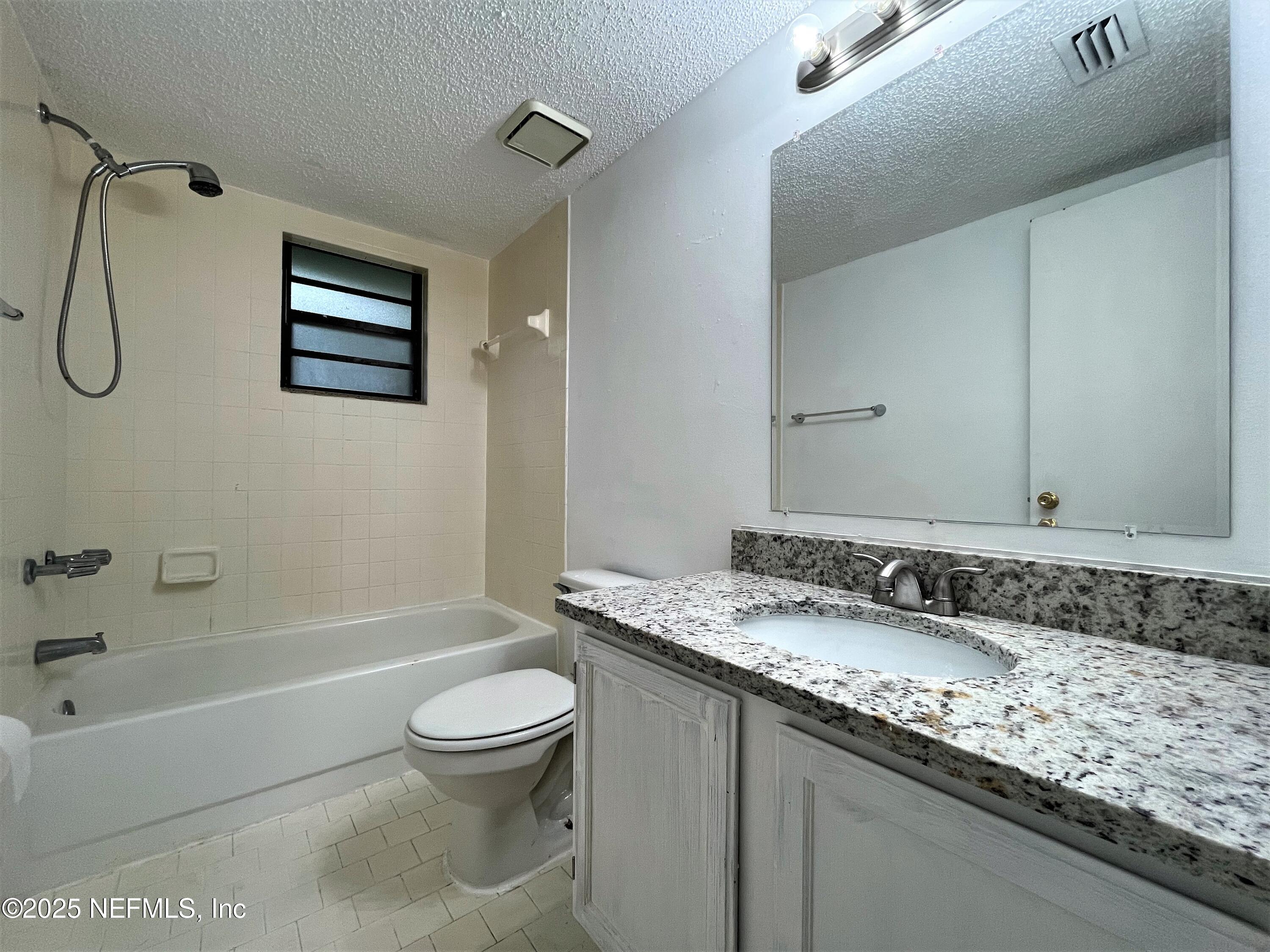 2910 Post Street Jacksonville, FL 32205 - Photo 10 of 12 a bathroom with a granite countertop sink a toilet and a bathtub