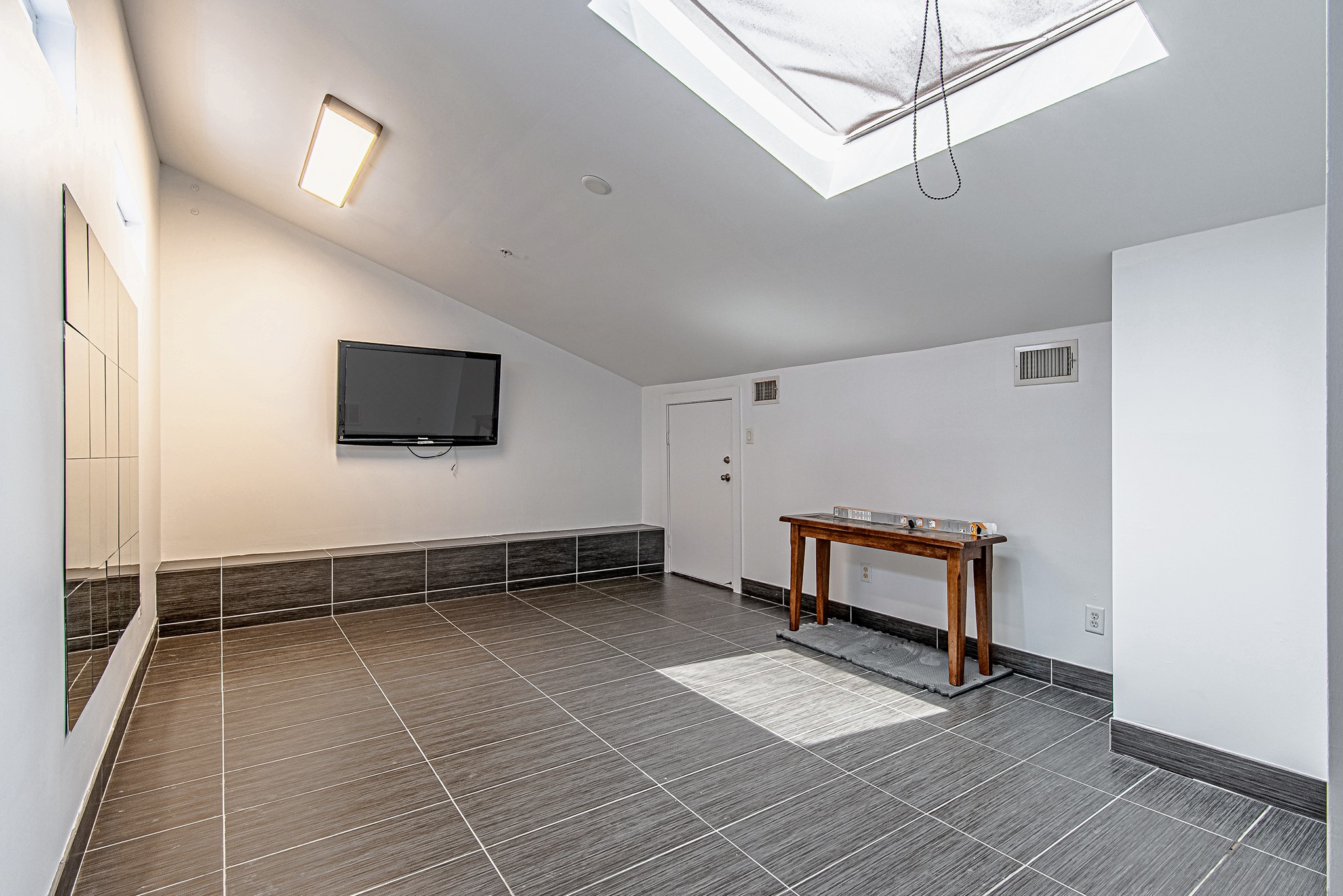 2025 Colquitt Street, Unit E Houston, TX 77098 - Photo 26 of 29 Versatile indoor space with skylight, ideal for a lounge, office, or gym.