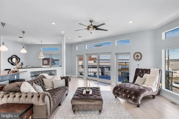 a living room with furniture a rug kitchen view and a chandelier