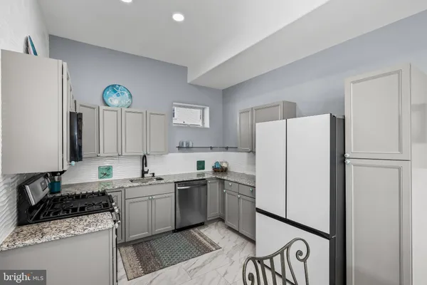 a kitchen with stainless steel appliances granite countertop a refrigerator stove and sink