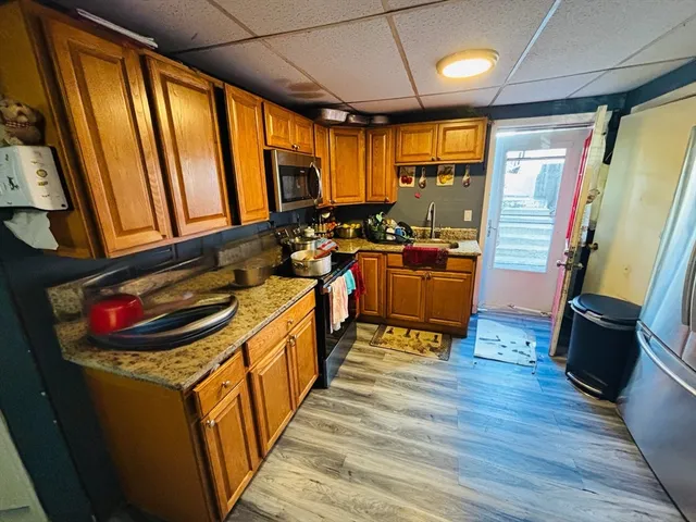 a kitchen with sink refrigerator and wooden floor