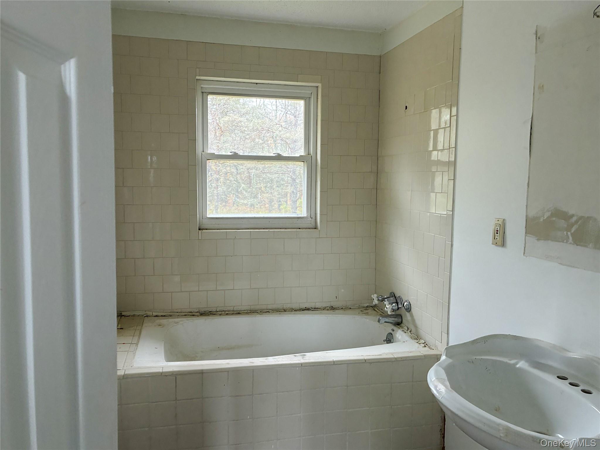 938 Horseshoe Lake Road Swan Lake, NY 12783 - Photo 7 of 8 a bath tub sitting next to a white toilet and vanity