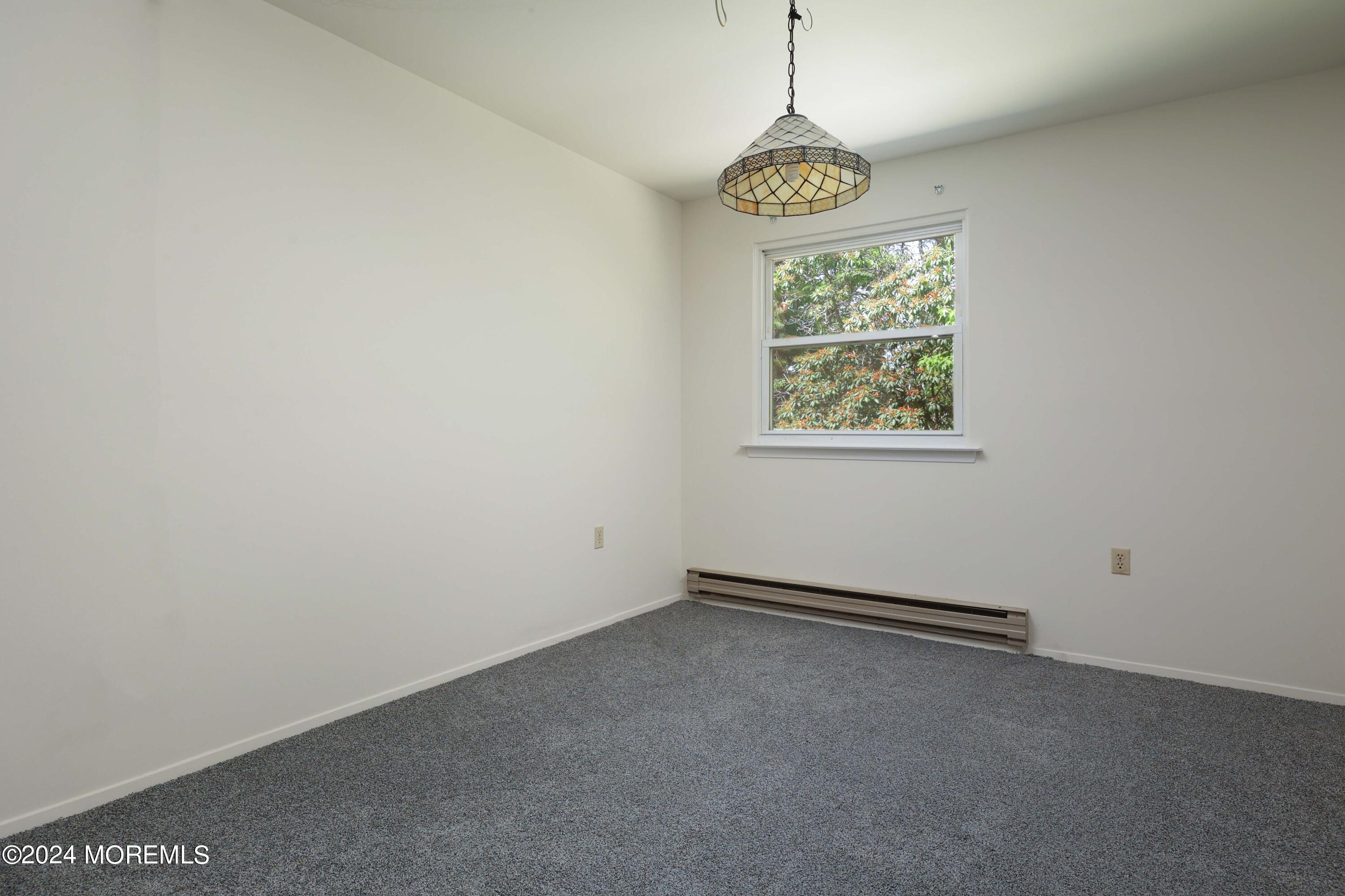 147A Sunset Road, Unit B Whiting, NJ 08759 - Photo 15 of 23 a view of an empty room with window and chandelier fan