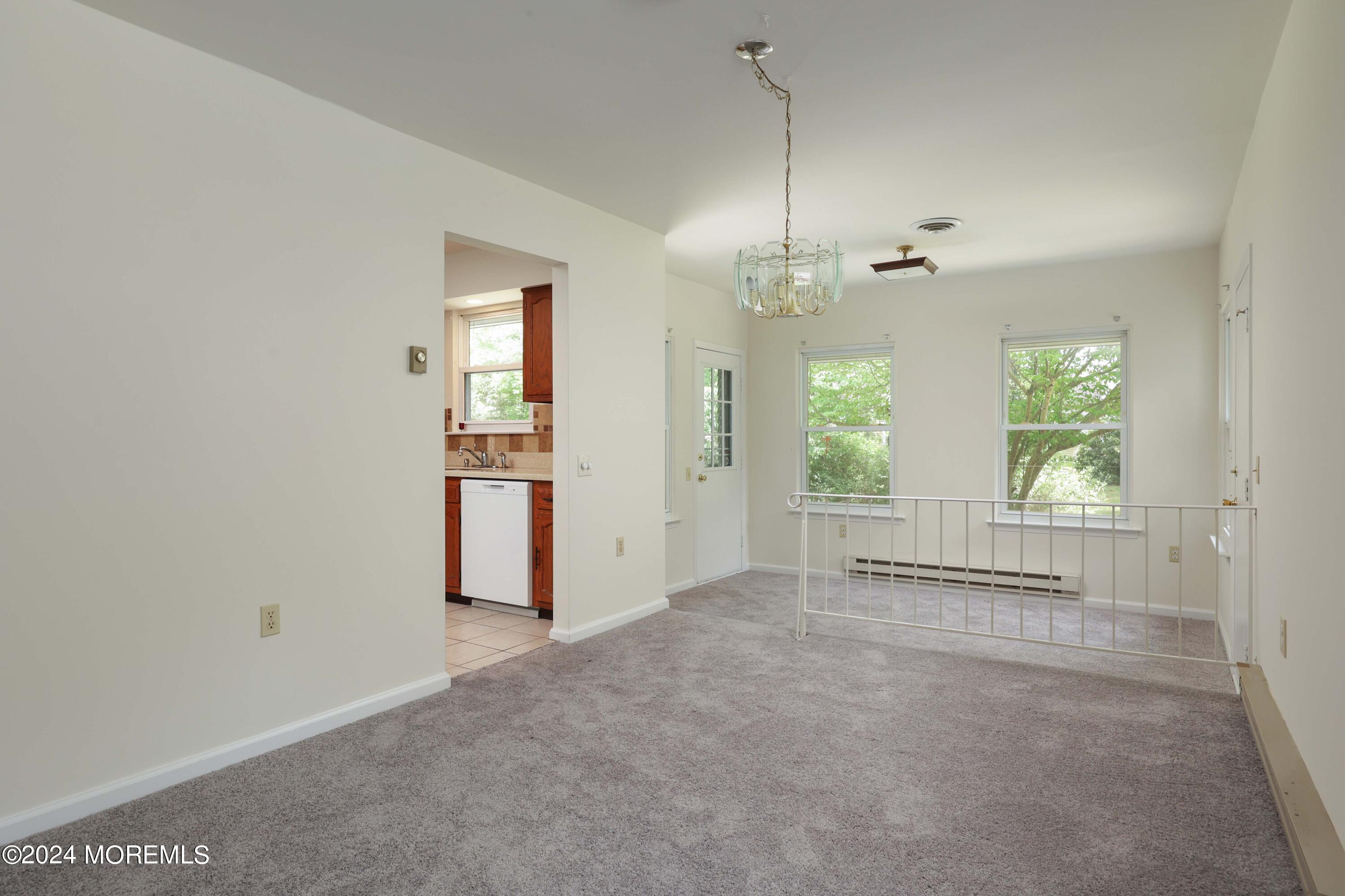 147A Sunset Road, Unit B Whiting, NJ 08759 - Photo 6 of 23 an empty room with chandelier and windows