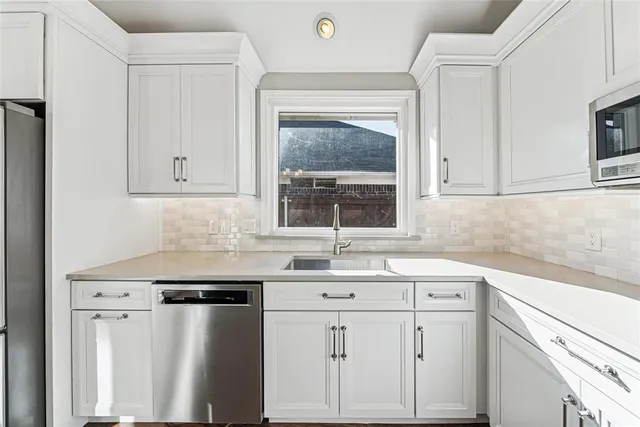 a kitchen with stainless steel appliances a sink and cabinets
