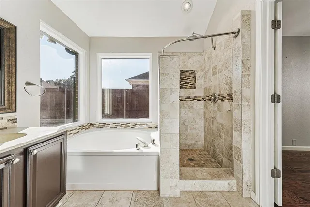 a bathroom with a tub sink and mirror