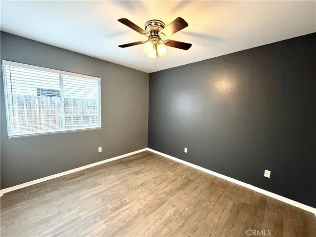 an empty room with a window and a fan