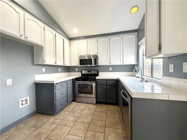 a kitchen with a sink a stove top oven and cabinets