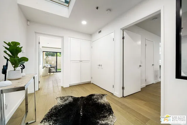 a living room with hardwood floor and a potted plant