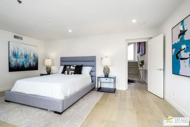 a bedroom with a large bed and paintings on the wall