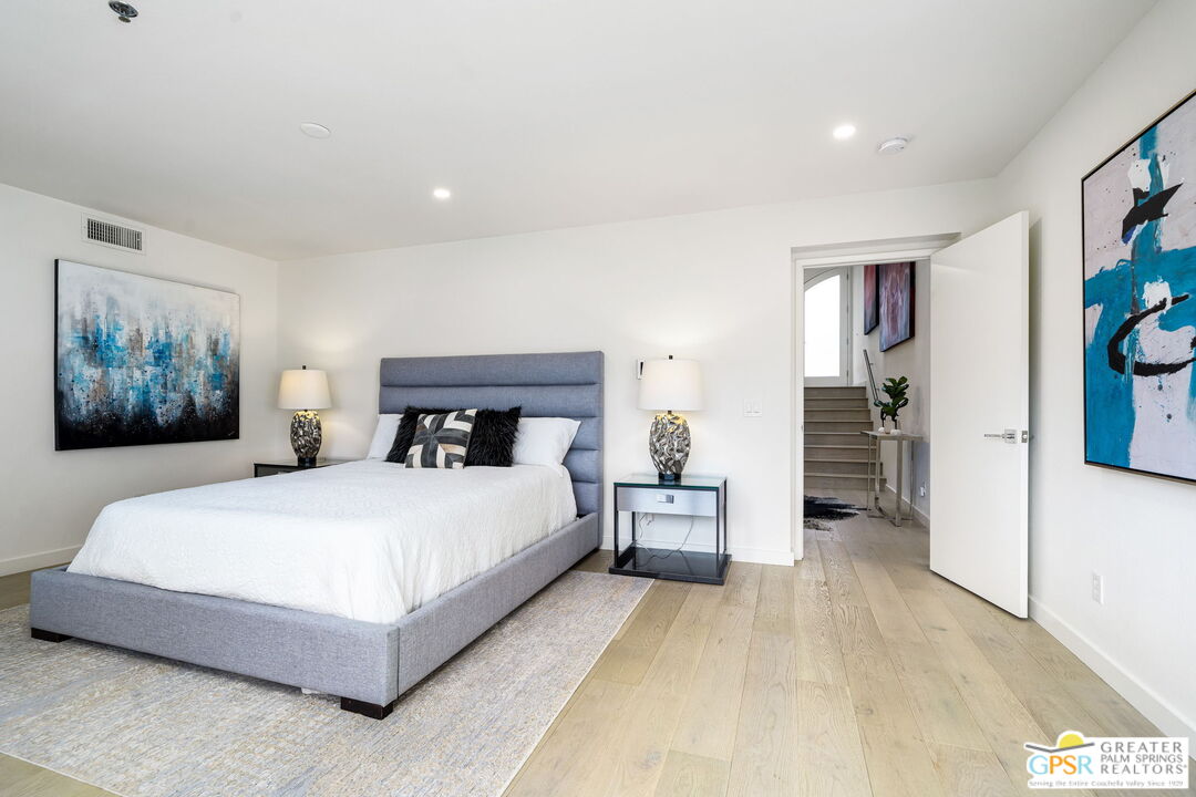 100 East Stevens Road, Unit 513 Palm Springs, CA 92262 - Photo 13 of 26 a bedroom with a large bed and paintings on the wall