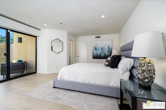 a bedroom with a bed and wooden floor