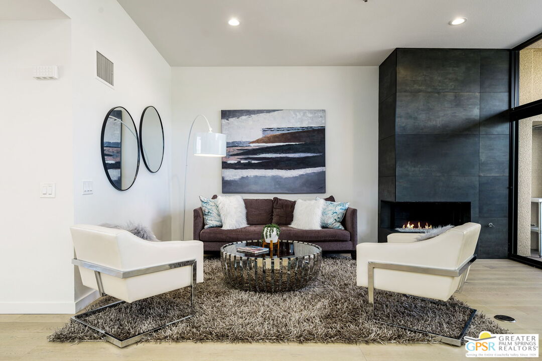100 East Stevens Road, Unit 513 Palm Springs, CA 92262 - Photo 2 of 26 a living room with furniture a rug and a fireplace