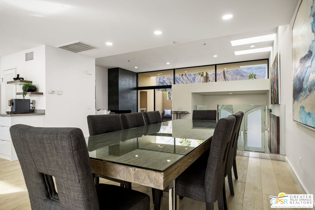 100 East Stevens Road, Unit 513 Palm Springs, CA 92262 - Photo 10 of 26 a dining room with furniture a mirror and a chandelier