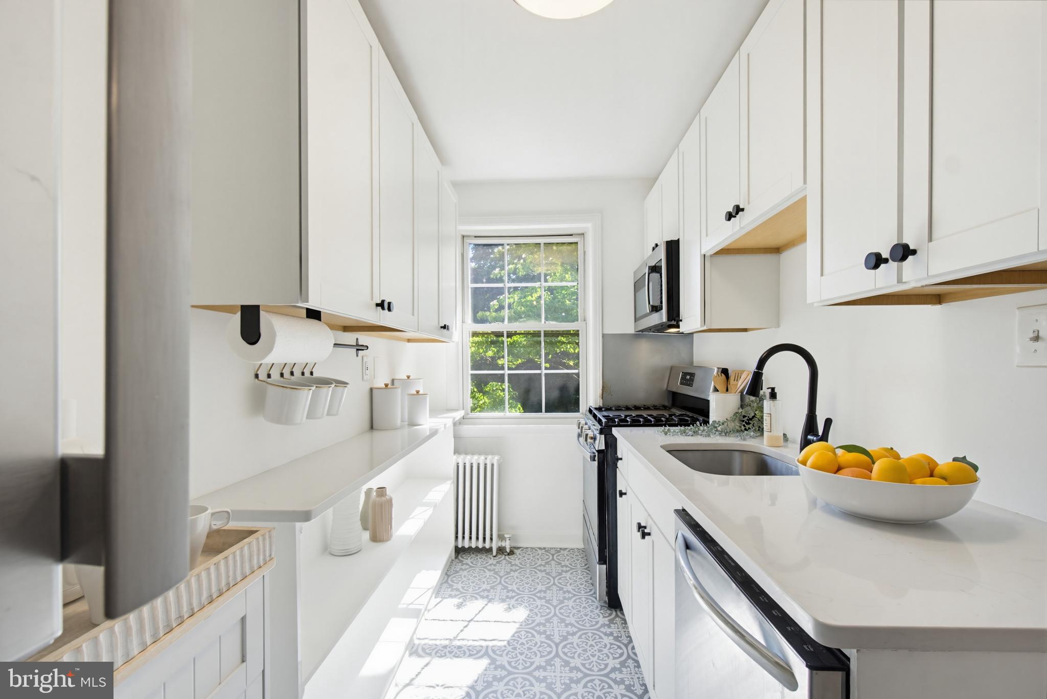 2214 Colston Drive, Unit 201 Silver Spring, MD 20910 - Photo 6 of 43 a kitchen with a sink a stove and white cabinets with wooden floor
