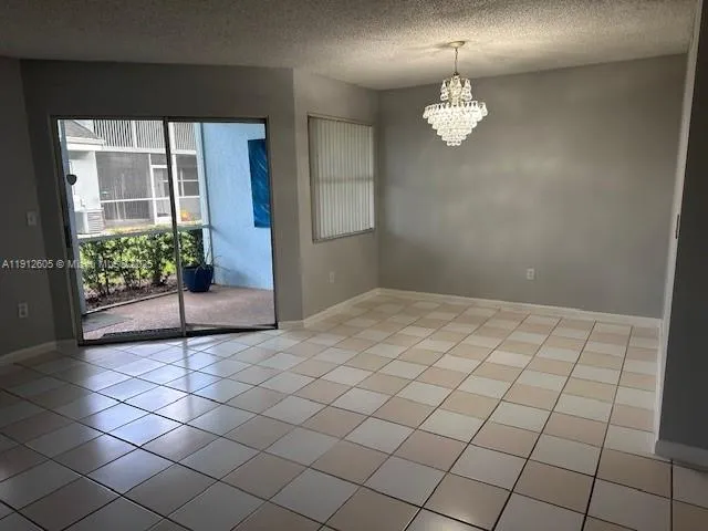 a view of a livingroom with a chandelier fan and windows