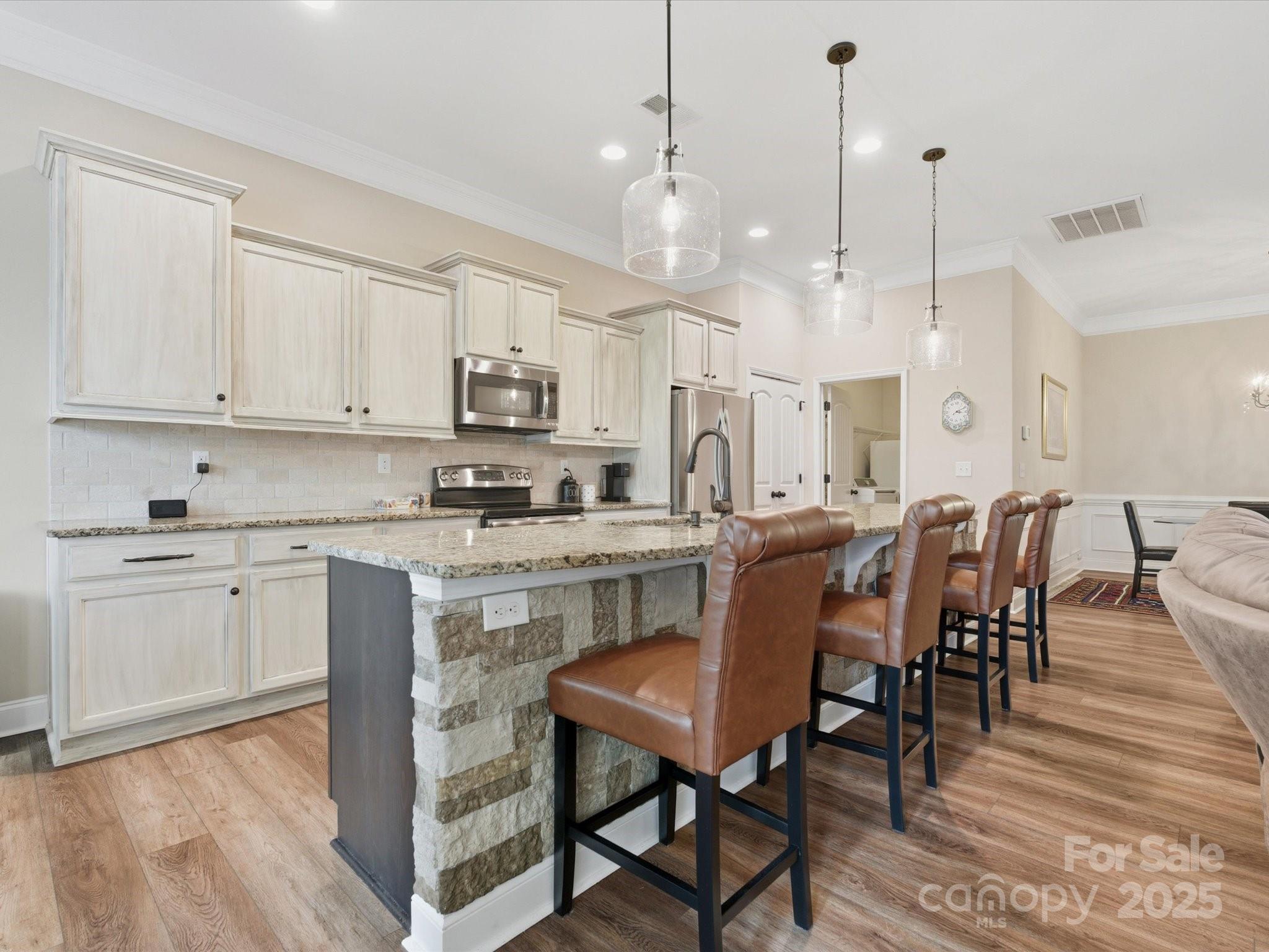 1326 Tupelo Road Clover, SC 29710 - Photo 12 of 40 a large kitchen with kitchen island a dining table chairs and white cabinets