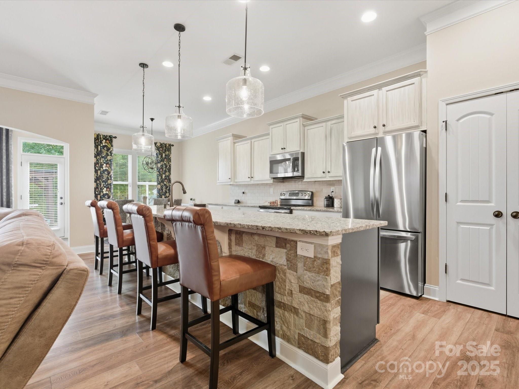 1326 Tupelo Road Clover, SC 29710 - Photo 14 of 40 a kitchen with kitchen island granite countertop a refrigerator a stove a sink a dining table and chairs with wooden floor