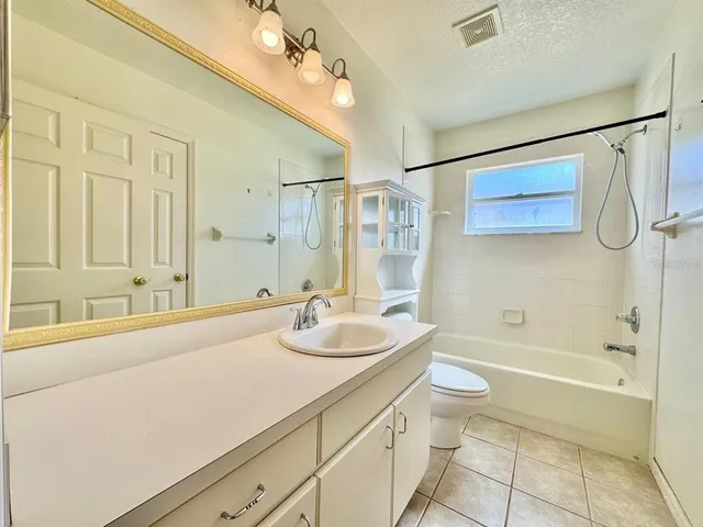 a bathroom with a granite countertop sink a toilet and shower