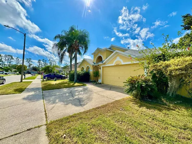 a view of a house with a yard and tree s