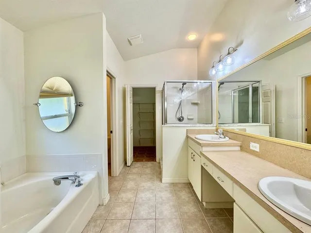 a spacious bathroom with a tub sink and mirror