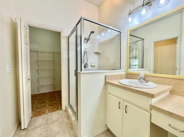 a bathroom with a shower sink and mirror