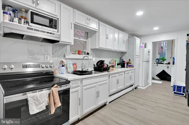 a kitchen with stainless steel appliances granite countertop a stove and cabinets
