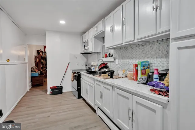 a kitchen with white cabinets and appliances