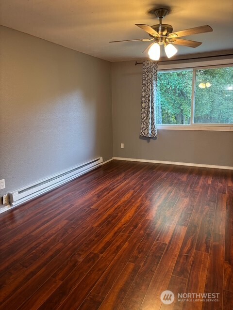 9735 Littlerock Road Southwest Olympia, WA 98512 - Photo 14 of 30 an empty room with wooden floor chandelier fan and windows
