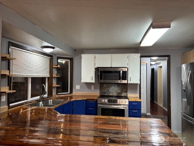 9735 Littlerock Road Southwest Olympia, WA 98512 - Photo 4 of 30 a kitchen with stainless steel appliances granite countertop a refrigerator a stove and a sink with wooden floors