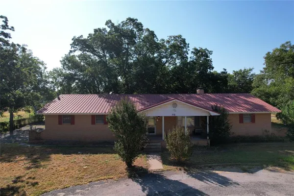 a view of a house with a yard and tree s