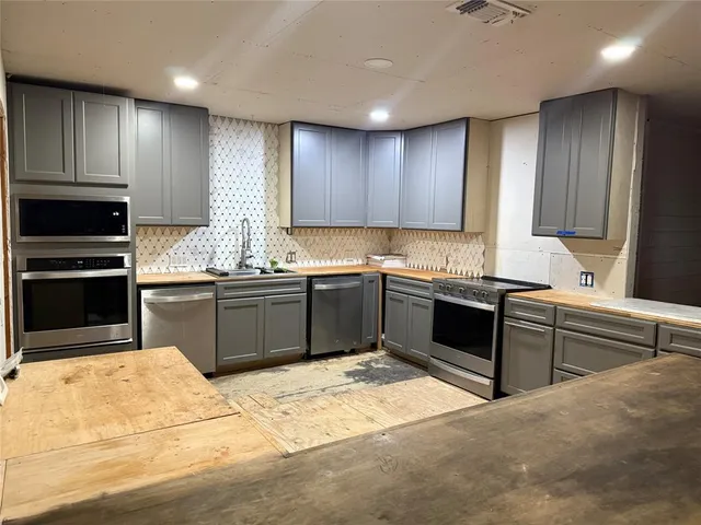a kitchen with stainless steel appliances granite countertop a sink and cabinets