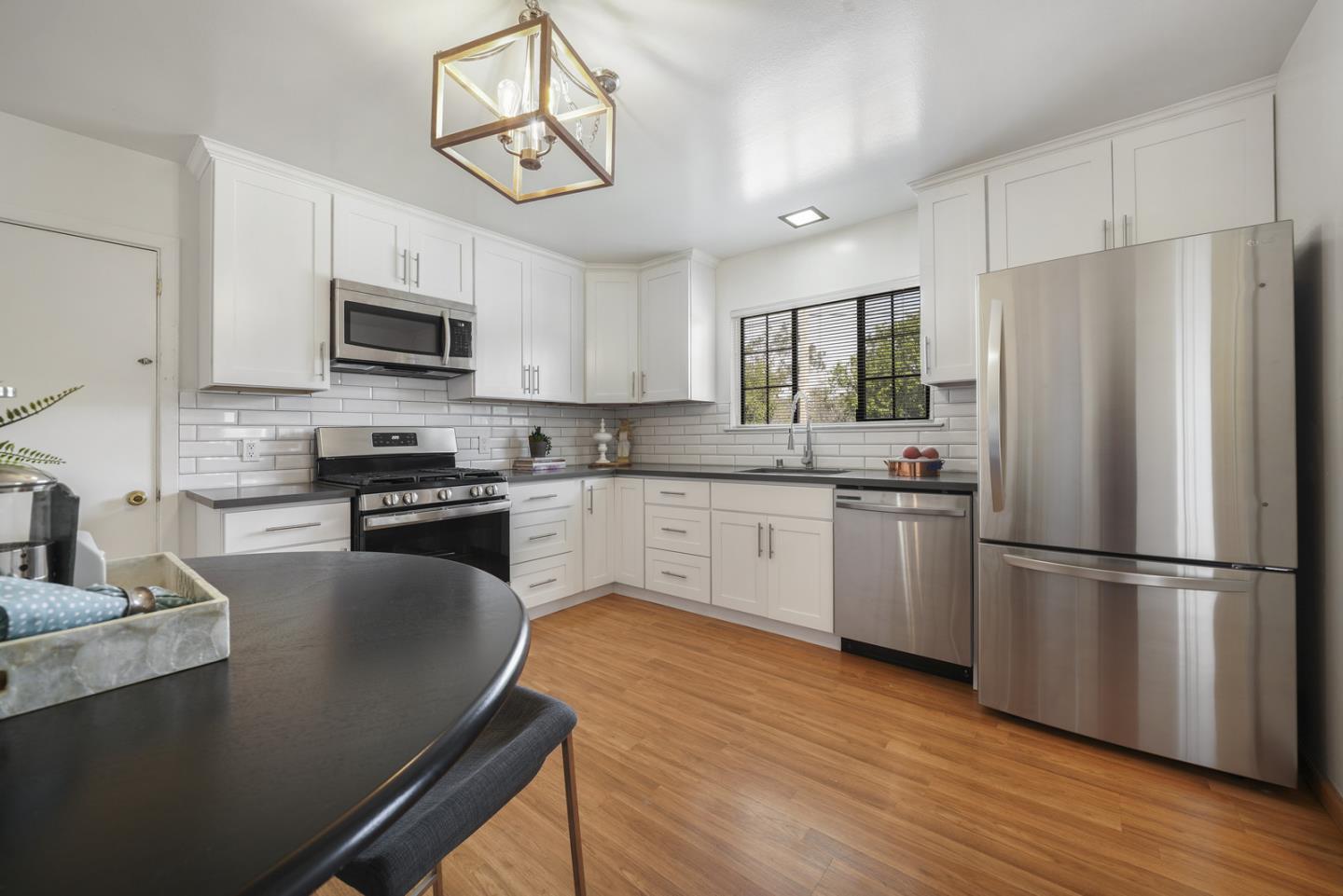 348 San Pablo Avenue Millbrae, CA 94030 - Photo 10 of 20 a kitchen with stainless steel appliances granite countertop a refrigerator a stove top oven a sink dishwasher and white cabinets with wooden floor