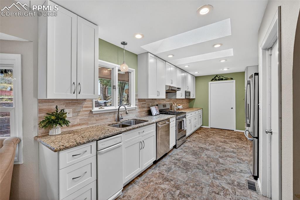 3102 Brenner Place Colorado Springs, CO 80917 - Photo 15 of 38 a kitchen with granite countertop a sink stainless steel appliances and cabinets