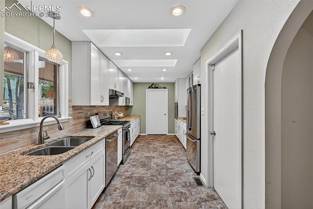 3102 Brenner Place Colorado Springs, CO 80917 - Photo 16 of 38 a large kitchen with a sink and cabinets