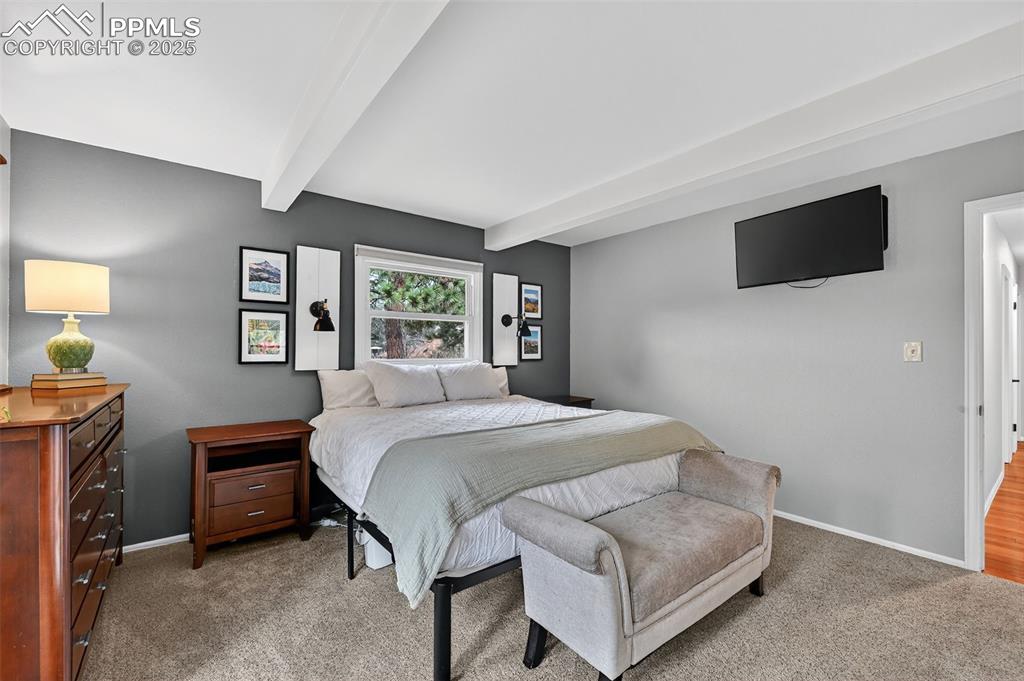 3102 Brenner Place Colorado Springs, CO 80917 - Photo 18 of 38 a bedroom with a bed a flat tv screen and a dresser