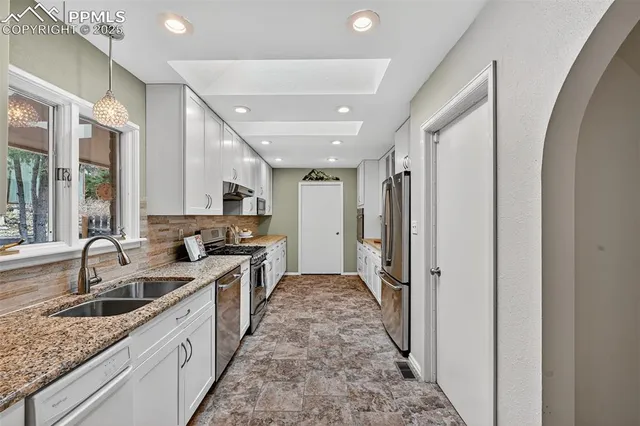 a large kitchen with a sink and cabinets