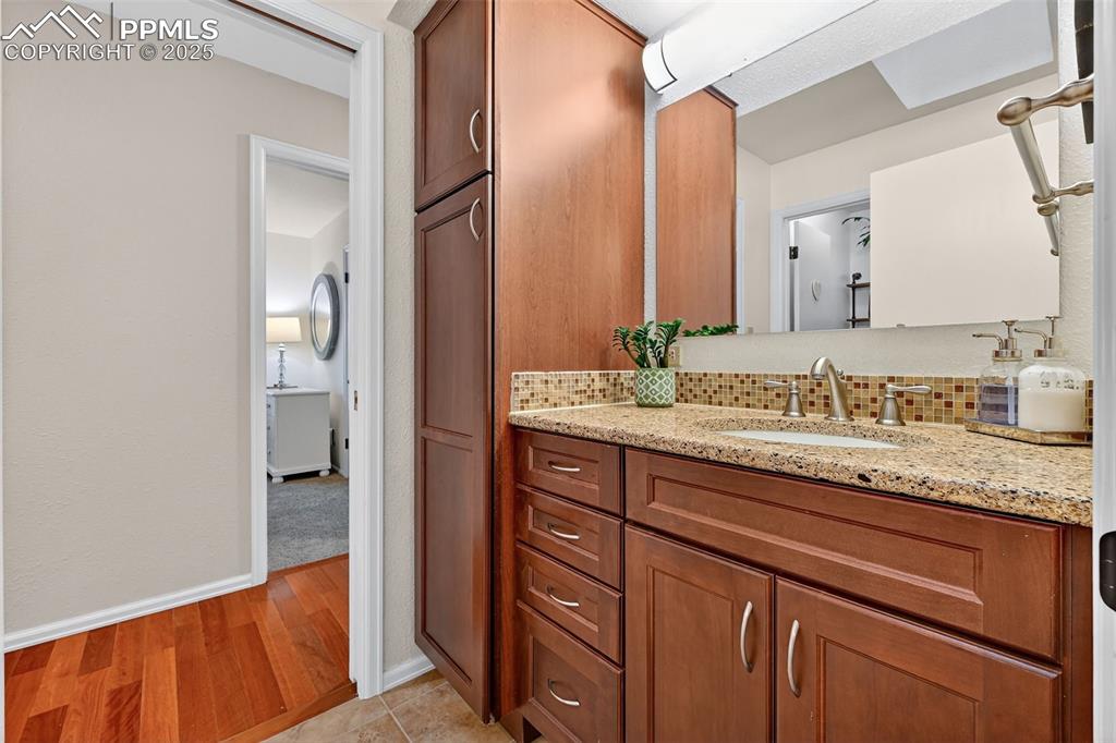 3102 Brenner Place Colorado Springs, CO 80917 - Photo 24 of 38 a bathroom with a granite countertop sink and a mirror