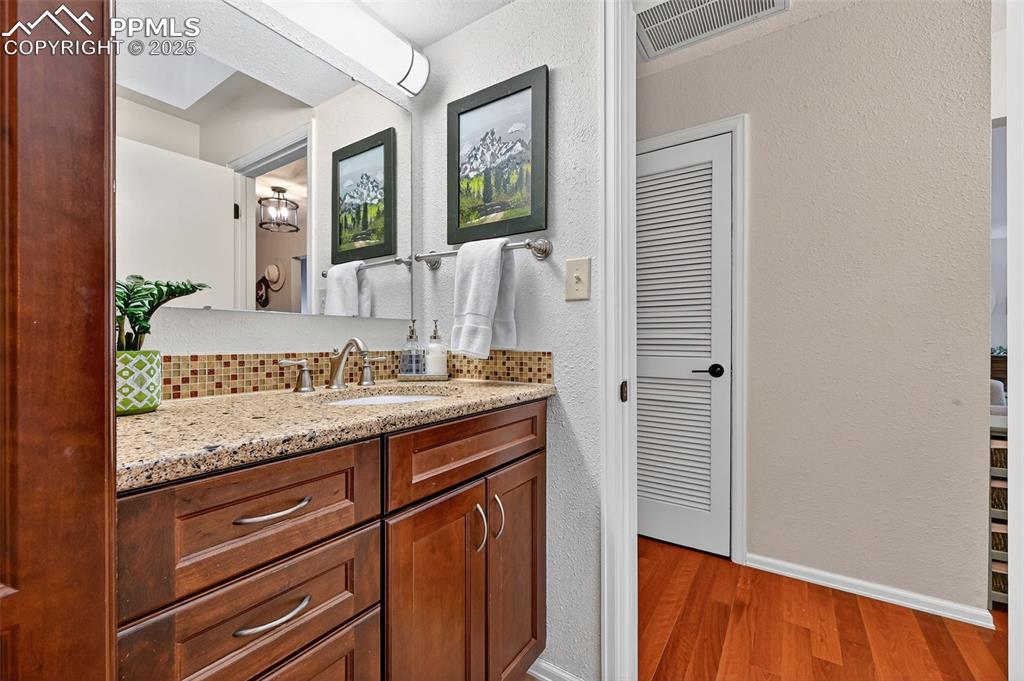 3102 Brenner Place Colorado Springs, CO 80917 - Photo 25 of 38 a bathroom with a granite countertop sink and a mirror