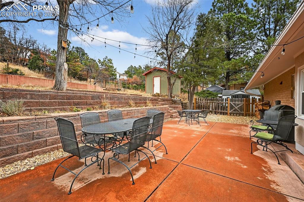 3102 Brenner Place Colorado Springs, CO 80917 - Photo 36 of 38 a view of a patio with dining table and chairs with a fire pit