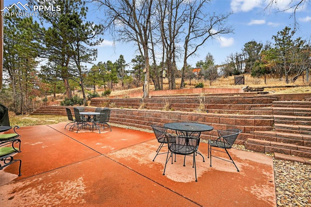 3102 Brenner Place Colorado Springs, CO 80917 - Photo 37 of 38 a view of a patio with table and chairs and couches with large trees
