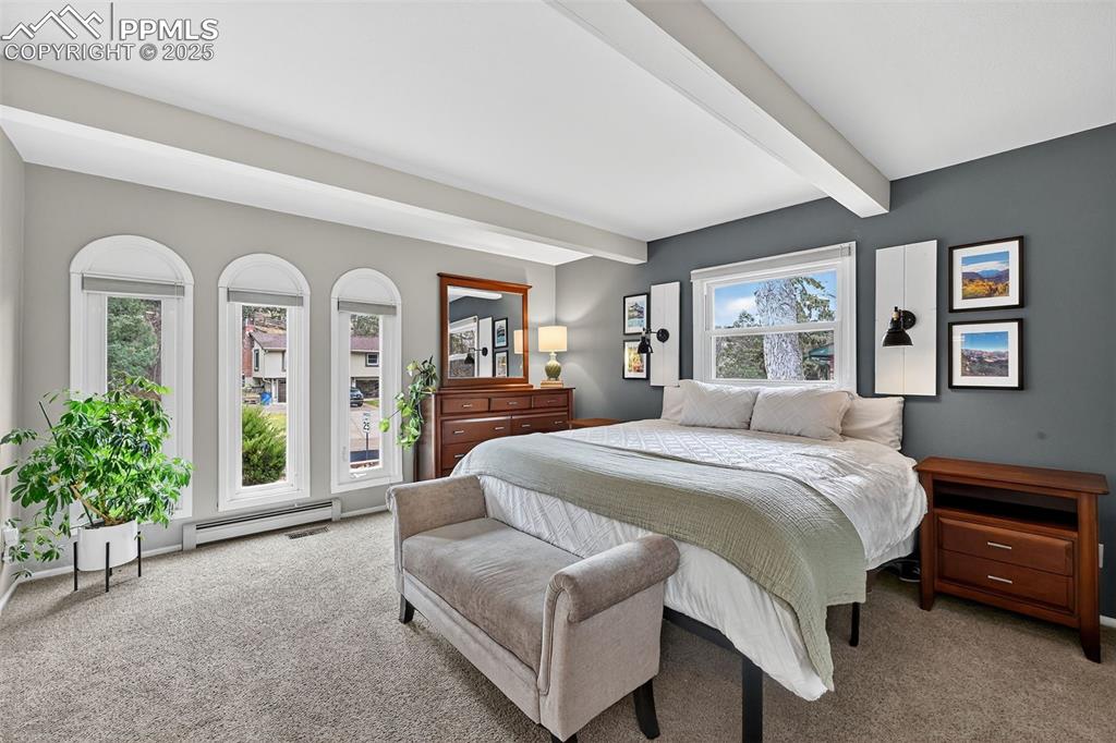 3102 Brenner Place Colorado Springs, CO 80917 - Photo 4 of 38 a spacious bedroom with a bed a mirror and a large window