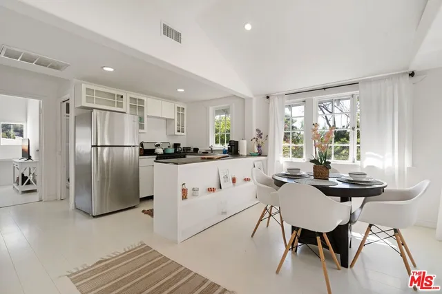 a living room with stainless steel appliances kitchen island granite countertop furniture and a refrigerator