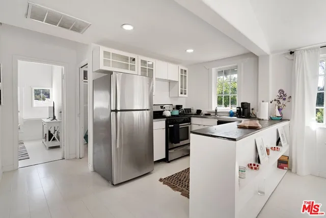 a kitchen with refrigerator and cabinets