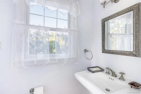 a bathroom with mirror sink and window