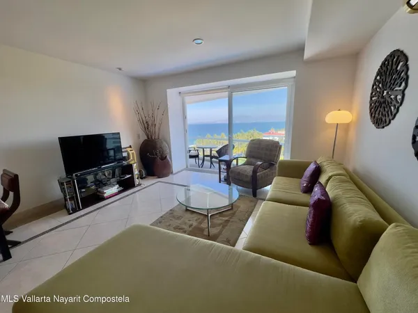 a living room with furniture a flat screen tv and a large window