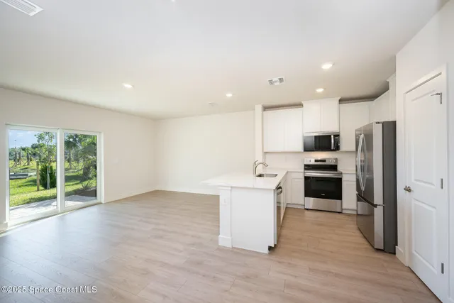 a kitchen with stainless steel appliances a refrigerator sink and microwave