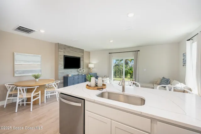 a kitchen with a sink and a flat screen tv
